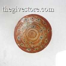 Ceramic bowl with brown and blue floral speckled design on a white background