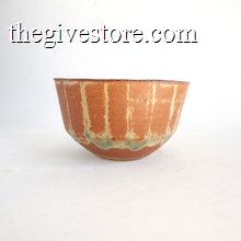 Ceramic bowl with brown and green glaze on a white background