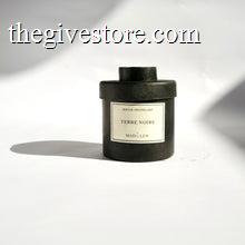 Black metal cylinder Mad et Len Candle Apothicaire Petite - TERRE NOIRE. Matching lid covering the candle. 